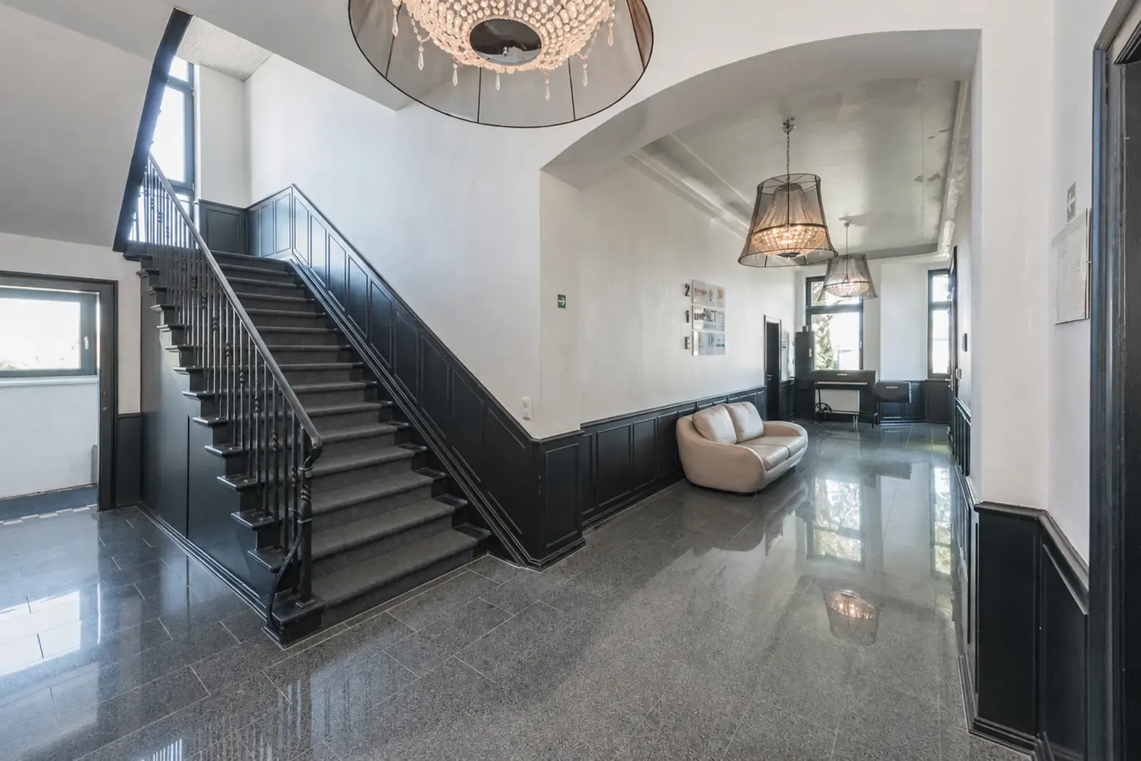 Repräsentative Eingangshalle mit Treppenaufgang und Designer-Leuchten